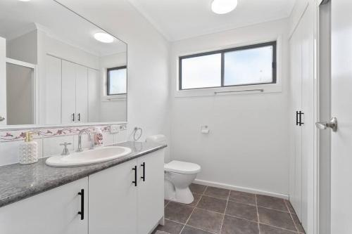 Un baño blanco con lavabo e inodoro. en The Station Mornington, en Mornington