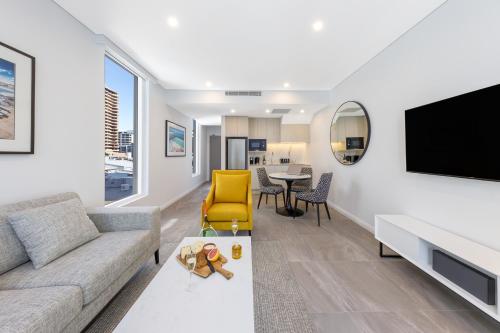 a living room with a couch and a tv at Meriton Suites Bondi Junction in Sydney