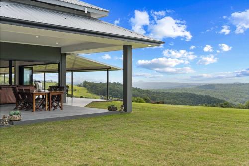 a patio with a table on a hill with a view at Panorama Farm - 3BD Hinterland Hideaway in Bald Knob