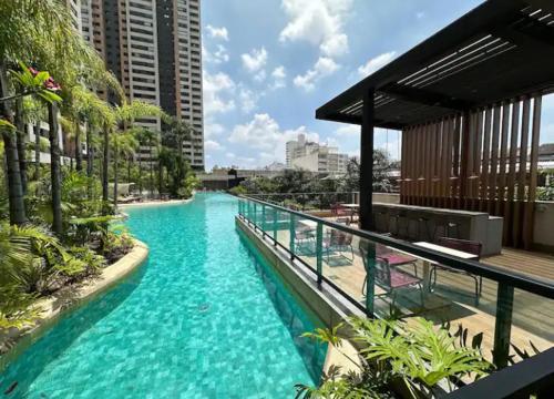 a swimming pool with blue water on a building at Quarto Individual Confortável em resort no Brás in Sao Paulo