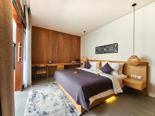 ein Schlafzimmer mit einem großen Bett und einem Schreibtisch in der Unterkunft Silk Umalas by Nagisa Bali in Kerobokan