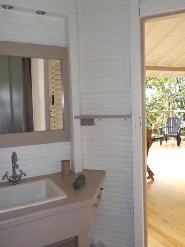 a bathroom with a sink and a mirror at Nati Lodge - Bungalow Guadeloupe in Bouillante