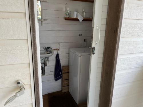 une salle de bain avec une machine à laver et un lavabo dans l'établissement Coquet Chalet à 50m de la Plage - 6 Pers, Terrasse, TV, Lave-vaisselle - FR-1-796-42, à Gruissan