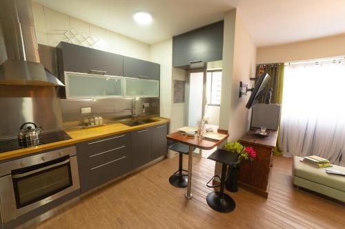 a kitchen with gray cabinets and a table in a room at Lujo, confort y seguridad para grupos familiares y parejas in Valencia