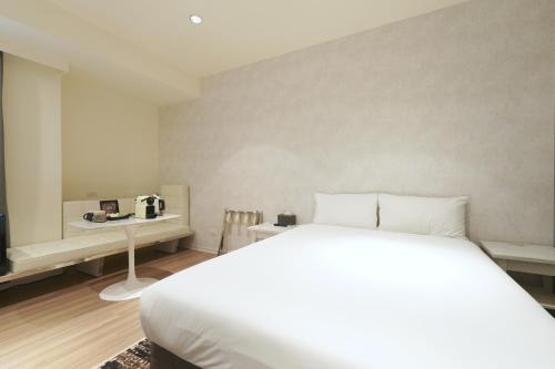 a bedroom with a white bed and a television at 秐朗文旅AKA Hotel in Taipei