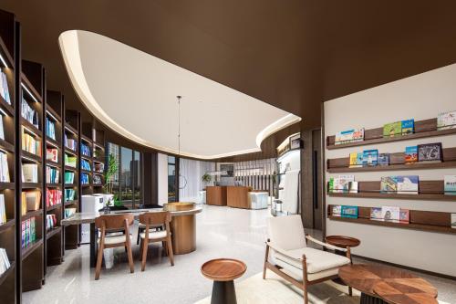 a library with chairs and tables and a large overhead light at Atour Hotel People's Square Metro Station Shanghai in Shanghai