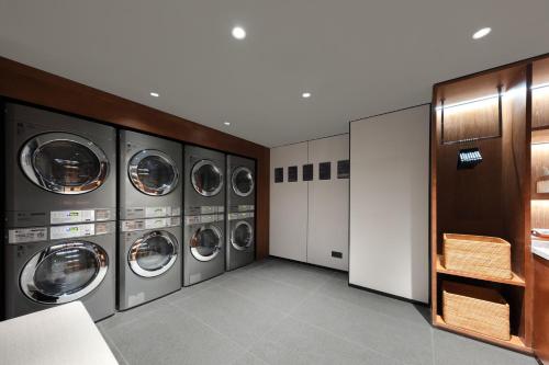 a laundry room with multiple washers and dryers at Atour Hotel People's Square Metro Station Shanghai in Shanghai