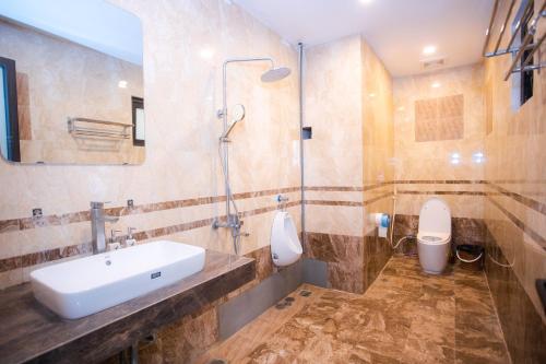 a bathroom with a sink and a toilet at King Bavi Resort in Ba Vì