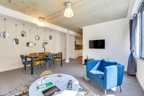 un salon avec un canapé bleu et une table dans l'établissement Sweett - La Roserie, à Paris