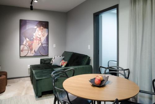 a living room with a green couch and a table at Cidade das bicicletas in Joinville