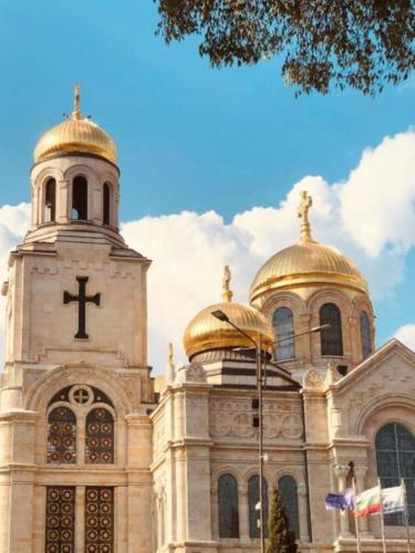 a church with gold domes and a cross on it at Hotel Elica in Varna City