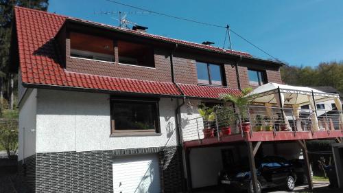 a house with a red roof and a balcony at Ferienwohnung Zenzen in Adenau
