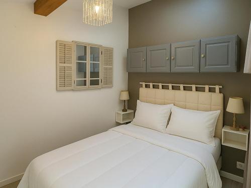 - une chambre avec un lit blanc et un lustre dans l'établissement Pavillon lumineux climatisé à 800m de la plage avec loggia et terrasse - 5 couchages - FR-1-732-16, à Argelès-sur-Mer