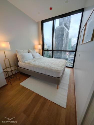 a bedroom with a bed and a large window at Newly Decorated Condo Near Siam Paragon in Bangkok
