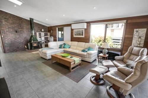 a living room with white furniture and a brick wall at Dun Ri in Paynesville