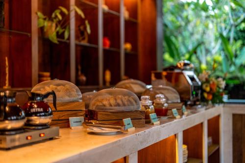 een toonbank met wat eten in glazen stolpen erop bij Radha Phala Resort & Spa in Ubud