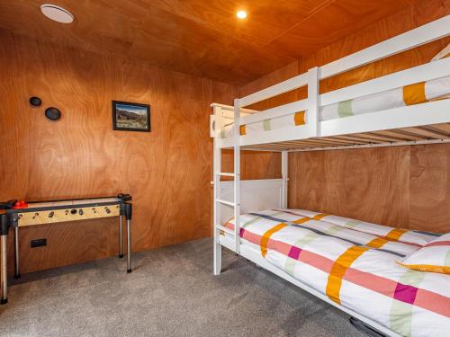 a bedroom with two bunk beds and a desk at Mountain Haus - Ohakune Holiday Home in Ohakune