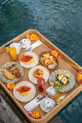 een tafel met borden eten op een boot bij Radha Phala Resort & Spa in Ubud