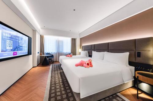 海口市にあるIntercity Hotel Haikou High Speed Rail East Stationのホテルの部屋のベッドに詰められた動物2匹