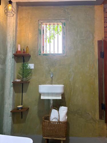 a bathroom with a sink and a window at Wild hikes River Escapes & Nature Views with Meals in Badureliya