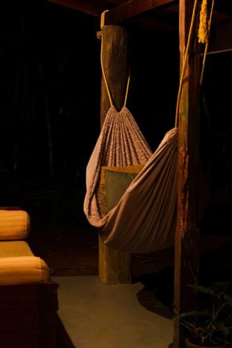 a hammock is hanging from a pole in a room at Wild hikes River Escapes & Nature Views with Meals in Badureliya
