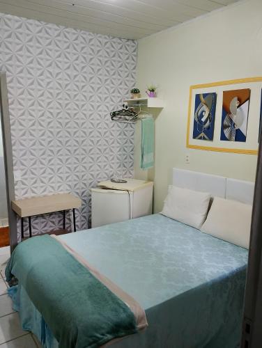 a bedroom with a bed and a chair in it at Pousada flores in Porto Velho