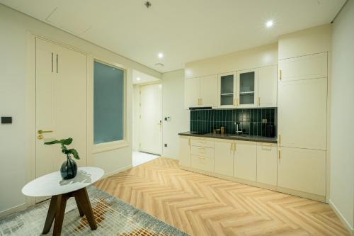 a large kitchen with white cabinets and a table at Epic Tower Swiss-Belresidences Hanoi in Hanoi