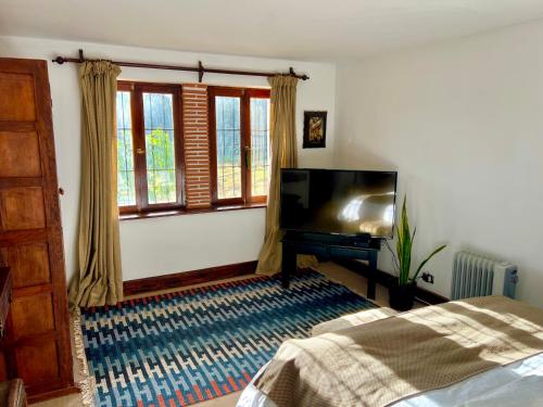 a bedroom with a bed and a flat screen tv at Inka Tambo Hacienda in Cusco