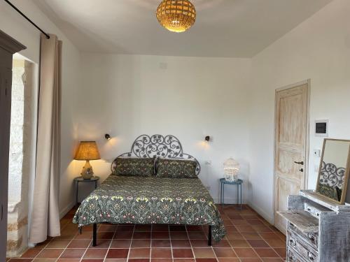 a bedroom with a bed and two tables and a lamp at Mater Familias Oasis in Siracusa