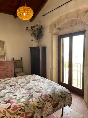 a bedroom with a bed and a large window at Mater Familias Oasis in Siracusa