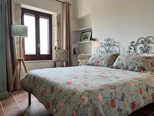 a bedroom with a bed and a window at Mater Familias Oasis in Siracusa