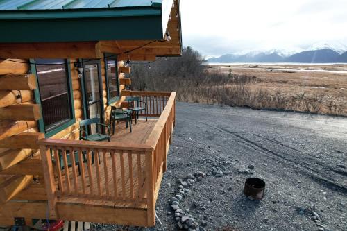 a porch of a log cabin with a table and chairs at Sockeye Cabin in Seward