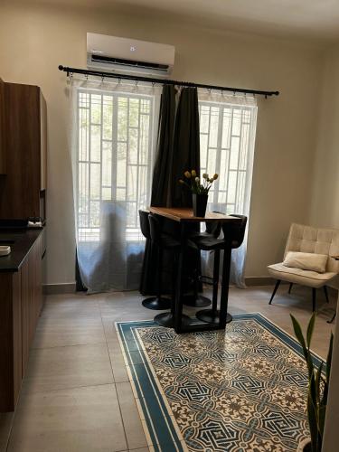 a living room with a table and chairs and windows at Apartamento completo planta baja Colonia Moderna in Guadalajara