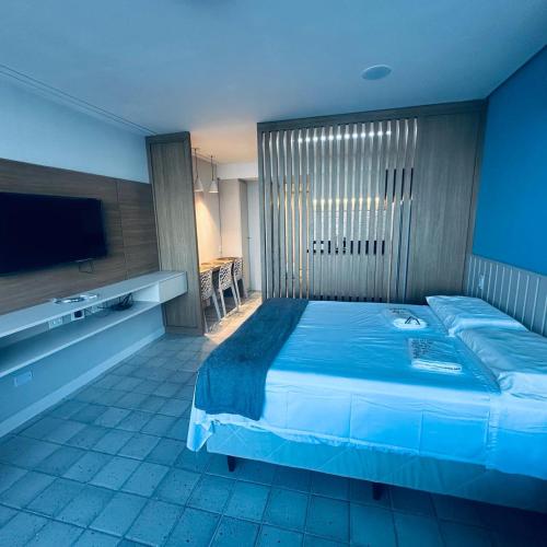 a bedroom with a large bed and a television at FLAT PRAIA DE PIEDADE - Região de Recife - Vista pro MAR in Recife
