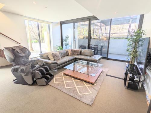 a living room with a couch and a glass table at The Loft 3BDR, City Centre, Family-Friendly, King Bed, Massage Chair, Parking in Canberra
