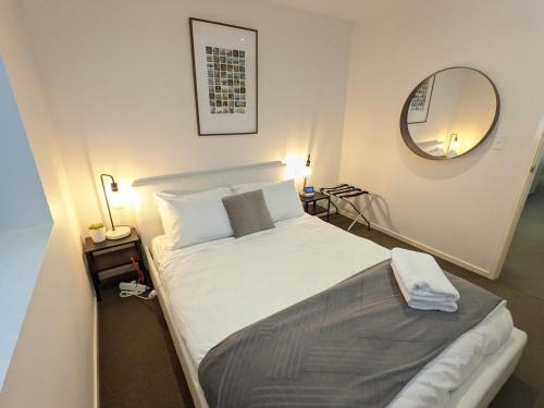 The Loft 3BDR, City Centre, Family-Friendly, King Bed, Massage Chair, Parking في كانبرا: غرفة نوم بها سرير كبير ومرآة
