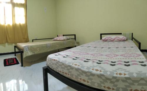 une chambre avec deux lits et une fenêtre dans l'établissement Isora Transit Villa, à Andiambalama