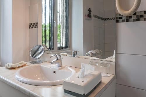 a bathroom with a sink and a mirror at Hôtel Saint Jacques in Thorigné-sur-Dué