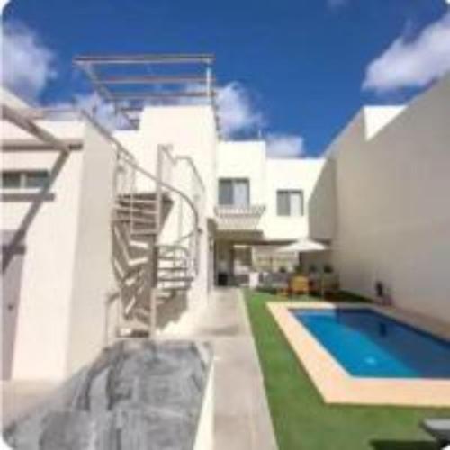 a white house with a swimming pool and a staircase at Casa Analía in San Carlos