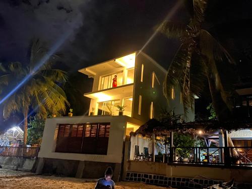 a man standing in front of a house at night at Villalola in Nosy Be