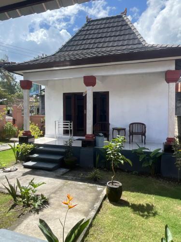 a small white house with a black roof at Batur OASE in Kubupenlokan