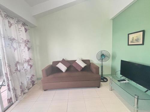 a living room with a couch and a flat screen tv at Ocean View Apartment-Near Blood Compact Shrine in Tagbilaran City
