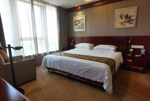a bedroom with a large bed in a room at Jinhua World Trade Hotel in Jinhua