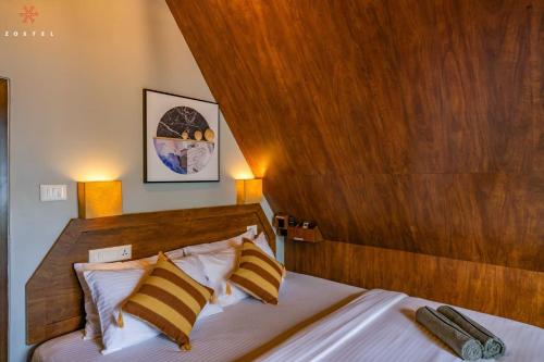 a bedroom with a large bed with a wooden headboard at Zostel Varkala in Varkala