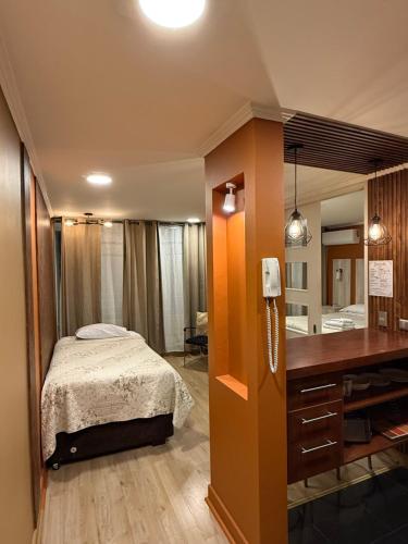 a bedroom with a bed and a desk with a phone at Turístico y familiar cercano al Costanera Centre in El Cerrillo