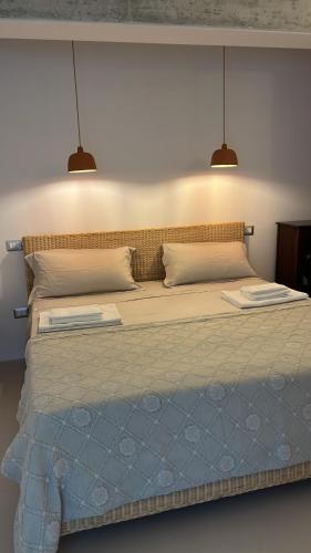 a bedroom with a large bed with two lights above it at Paradiso sul mare in Santa Cesarea Terme