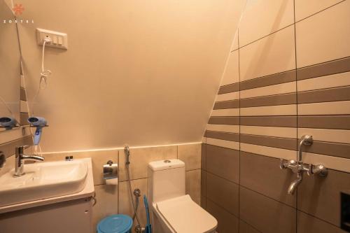 a small bathroom with a toilet and a sink at Zostel Varkala in Varkala