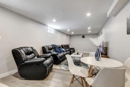a living room with leather furniture and a table at Luxury & private 3 bed basement unit kitchen, wifi, park, mall in London