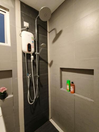 a shower in a bathroom with a shower head at JJ's Modern Suite Kampar- Near UTAR in Kampar