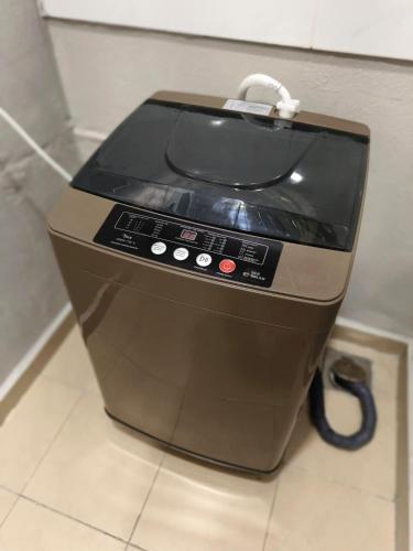 a toaster oven sitting on a tiled floor at JJ's Modern Suite Kampar- Near UTAR in Kampar